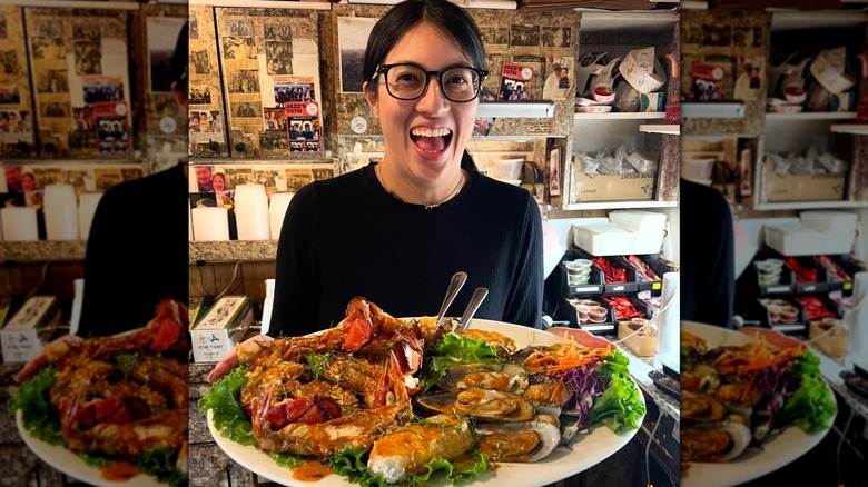 Smiling woman holding seafood platter at Jitlada in Los Angeles