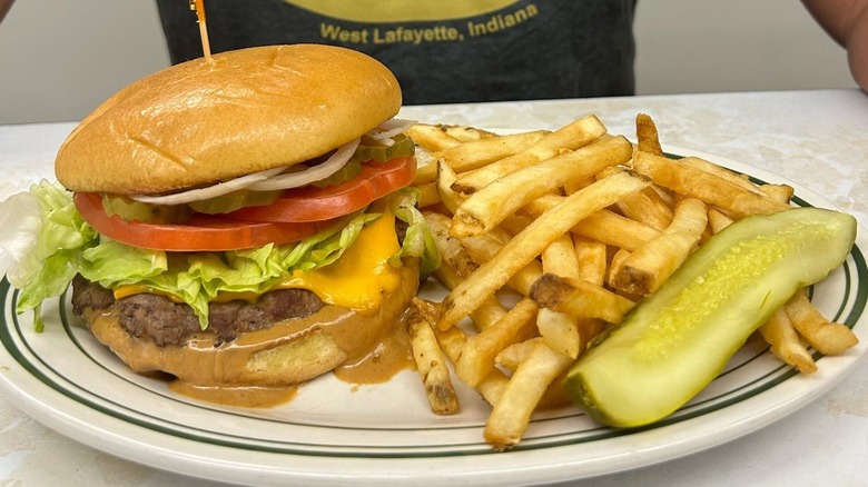White plate with cheeseburger, fries, and a pickle spear served at Triple XXX Family Restaurant