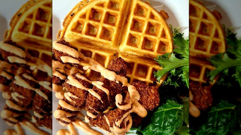Top-down shot of bang bang chicken and waffles next to lettuce leaf at A1 diner