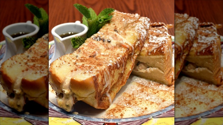 Close-up of carrot cake cheesecake stuffed French toast on plate, syrup and mint leaves behind Miss Shirley's Cafe