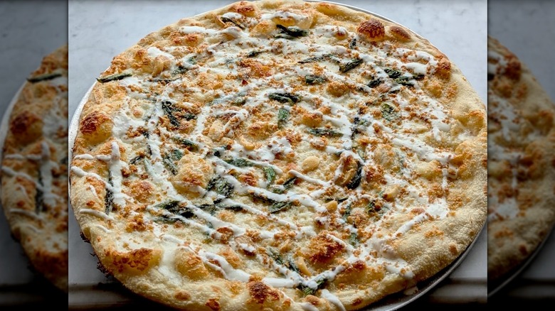 Asparagus and chevre pizza drizzled with white sauce