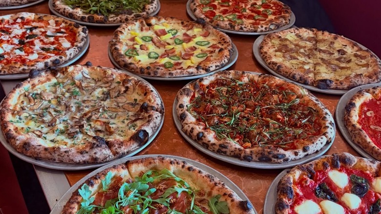 Several different pizzas displayed on table