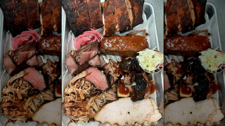 Top-down shot of metal tray piled with barbecued meats