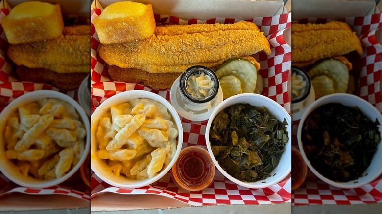 Top-down shot of basket with fried fish, collards, mac and cheese, cornbread