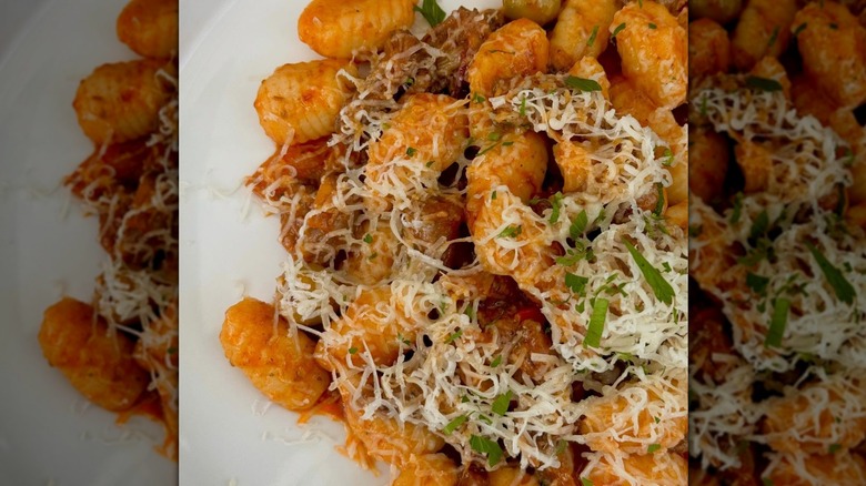 Close-up of cheesy gnocchi dish on white plate