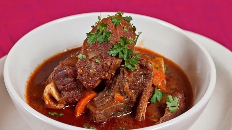 Close-up of beef stew with parsley garnish in white bowl