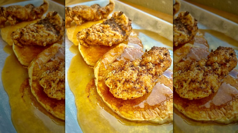 Close-up of fried chicken and syrup on pancakes