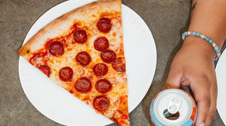 Top-down shot of slice of pepperoni pizza on white paper plate