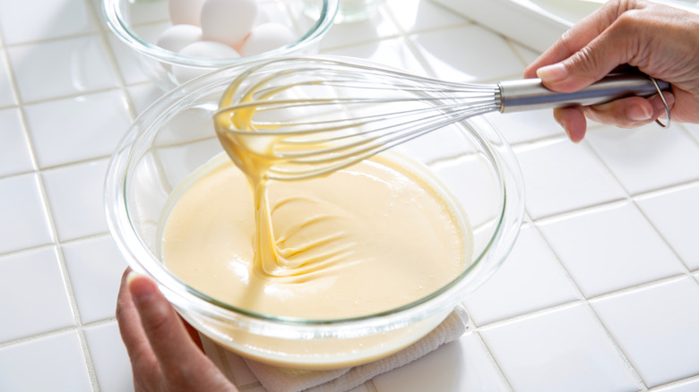 Someone whisks pancake batter in a bowl