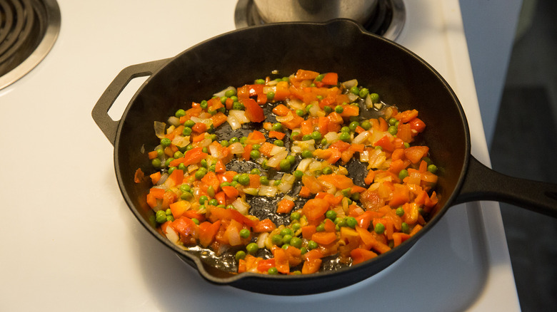 vegetables sauteing in iron pan