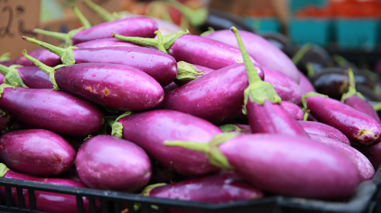 Purple eggplant on display in baskets at a market