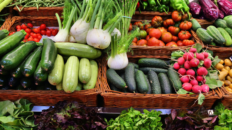 An array of fresh vegetables on display in wicker baskets at a farmers market