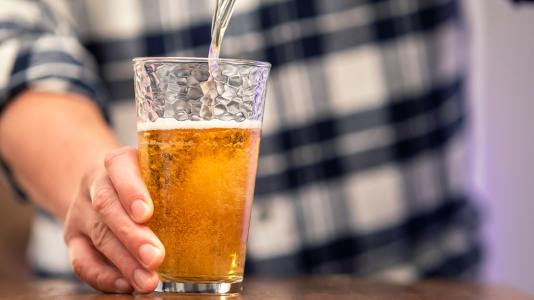 man pouring cream ale