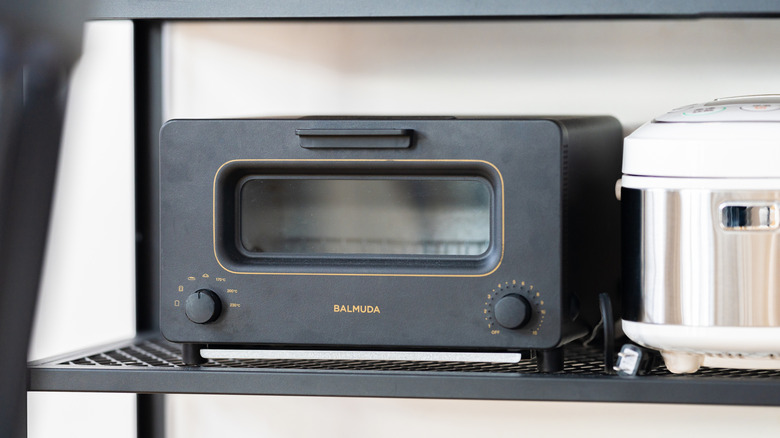 black Balmuda The Toaster on a shelf next to rice cooker