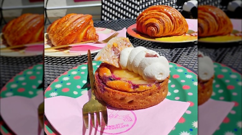 Mini meringue pie with fork and two croissants on table at Patisserie Jacqui