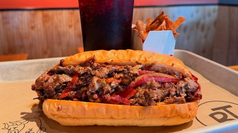 Brisket sandwich, fries, and soft drink on tray