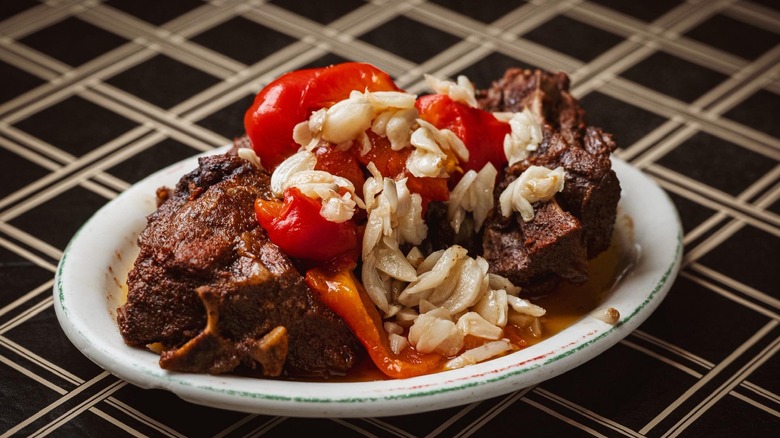 Plated baked lamb dish with tomatoes