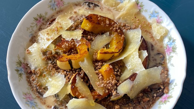 Plated stewed rye berries and mushrooms with squash and cheddar