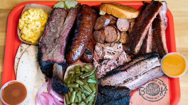 Top view of brisket, sausages, and green beans on tray