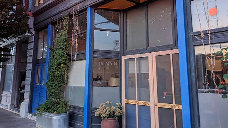 Wooden exterior of Bar Bacetto with potted plants
