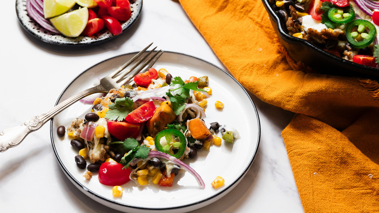 Serving of Southwest sweet potato skillet with skillet behind it
