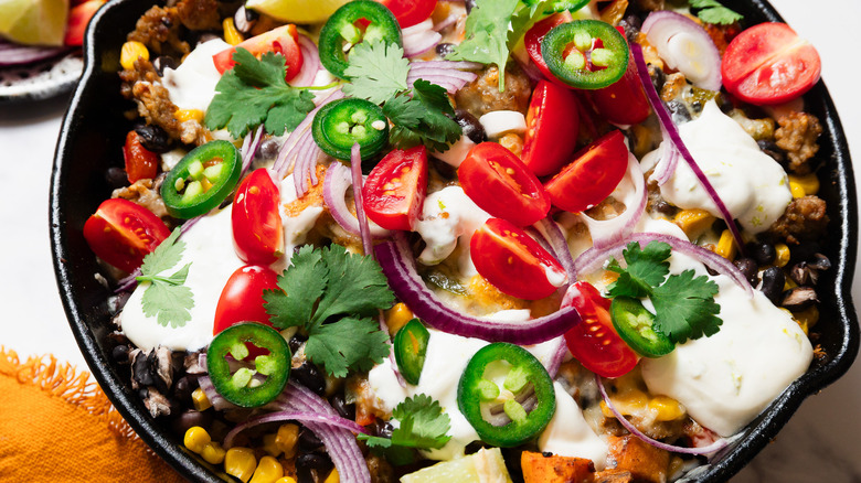 Southwest sweet potato skillet with toppings besides it