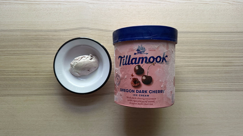 A carton of Tillamook Oregon Dark Cherry Ice Cream next to a bowl