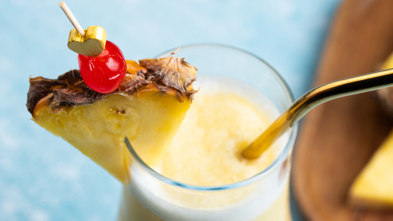 top view of a creamy pina colada with cherry and pinapple garnish