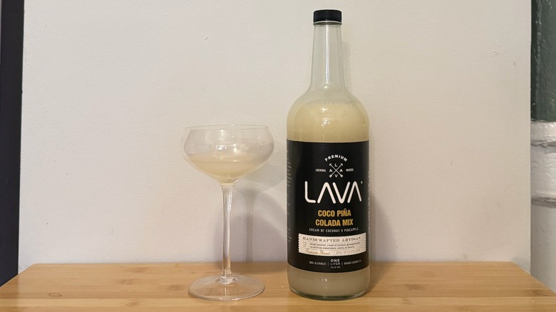 bottle of Lava Coco mix next to a cocktail glass