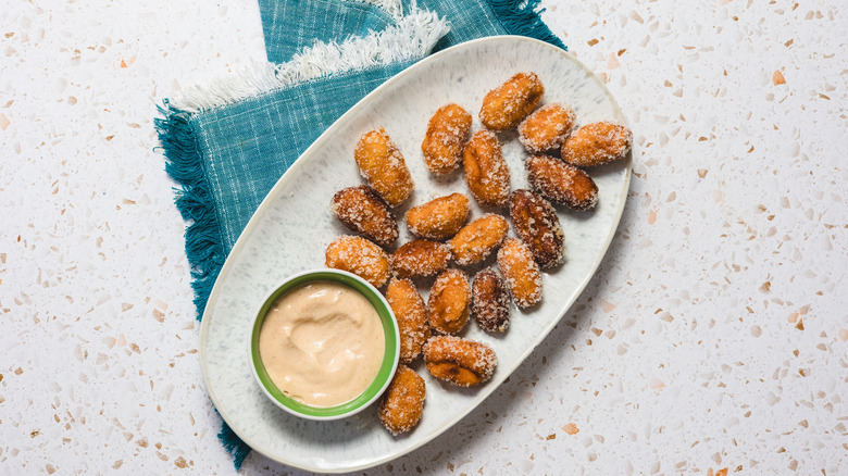 Sweet potato tater tots on oval dish with blue napkin