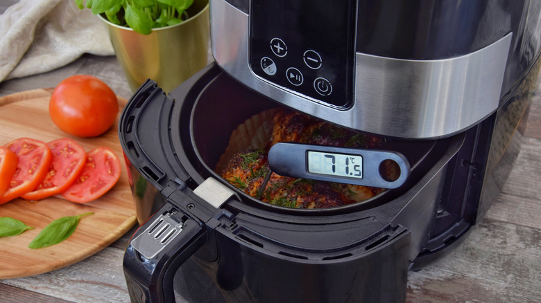an open air fryer basket with an instant thermometer sticking out