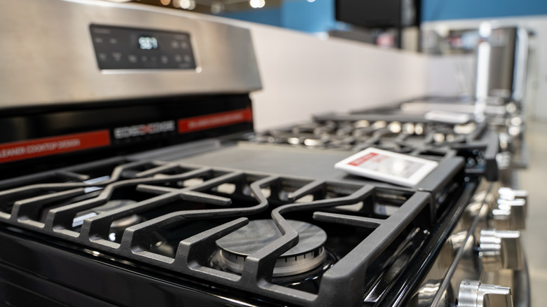 Row of display stoves in an appliance store.