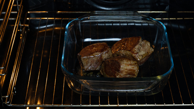 Pieces of meat cooking in an oven