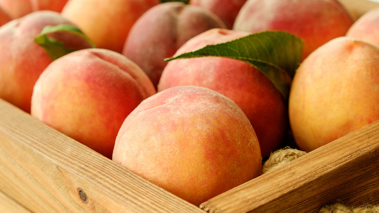 Fresh peaches in a wooden crate