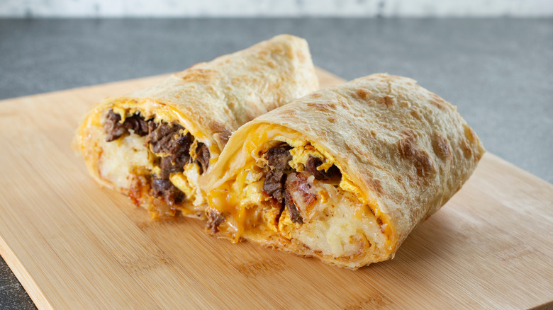 carne asada breakfast burrito on a wood board
