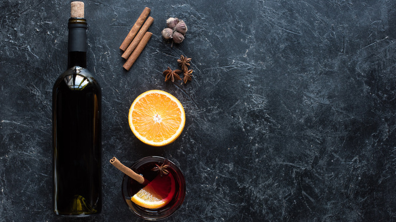 Glass of mulled wine with spices and orange wedge