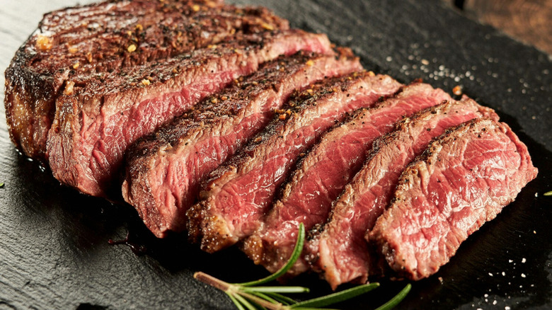 A crispy steak sliced on a stone plate