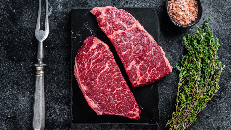 Raw Denver steaks on slate cutting board
