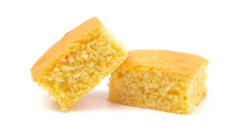 Two pieces of cornbread on a white background