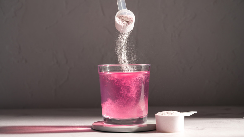 powder dropping into a glass of water