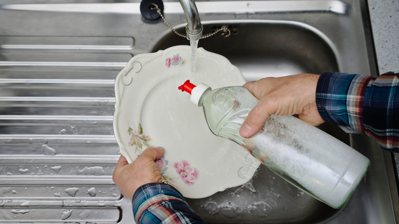 person washing a vintage plate
