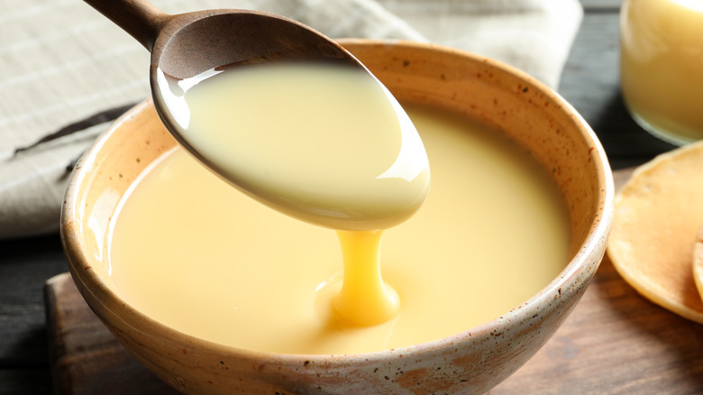 sweetened condensed milk in a wooden ladle