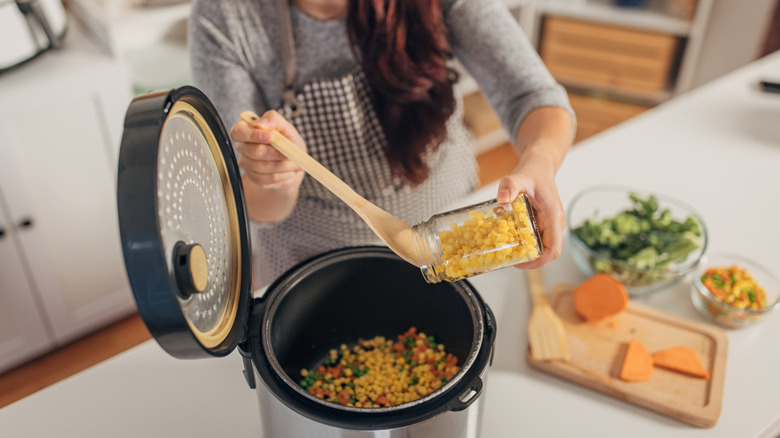 person cooking in kitchen in slow cooker