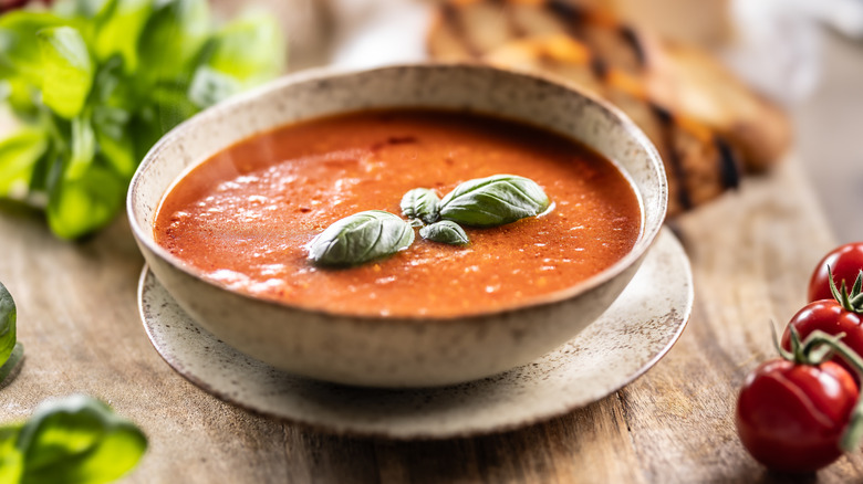 tomato soup in rustic bowl garnished with basil