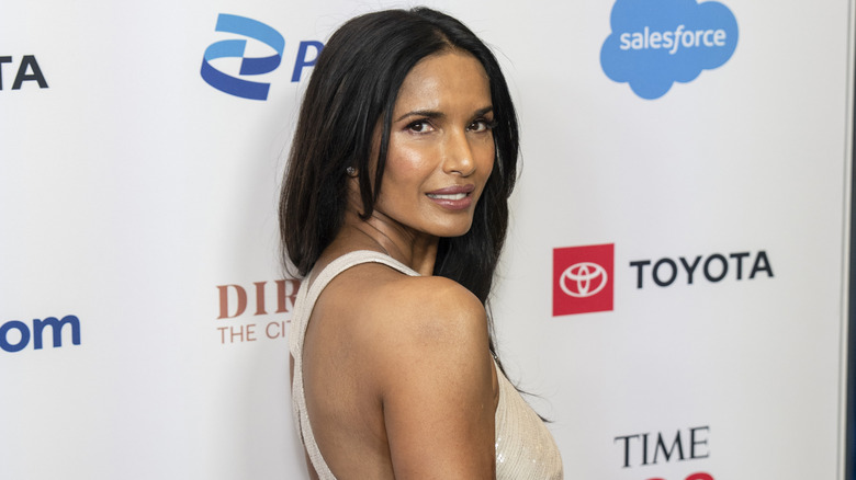 Padma Lakshmi looking back at the camera on a red acrpet