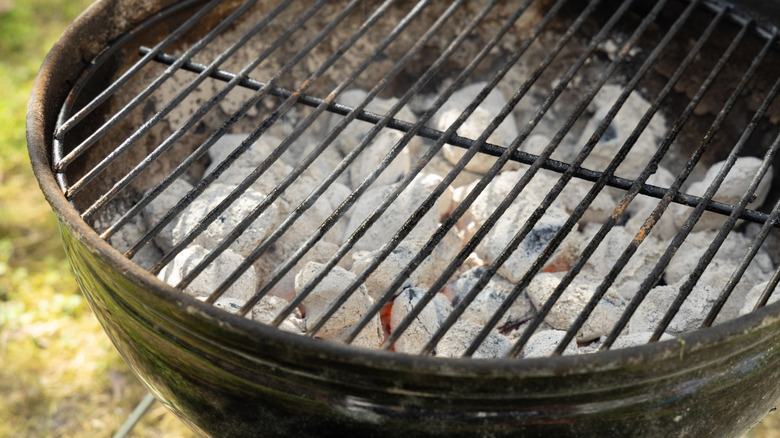 a grill filled with ash-covered charcoal