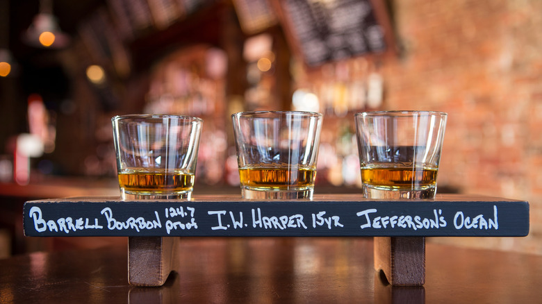 A whiskey flight of three samples inside bar