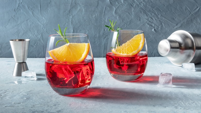 glasses of Negronis with oranges and herbs