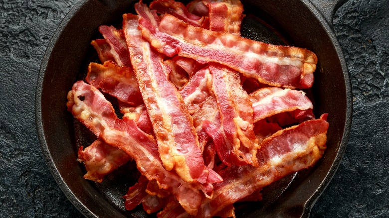Top-down view of a pile of cooked bacon in a pan 