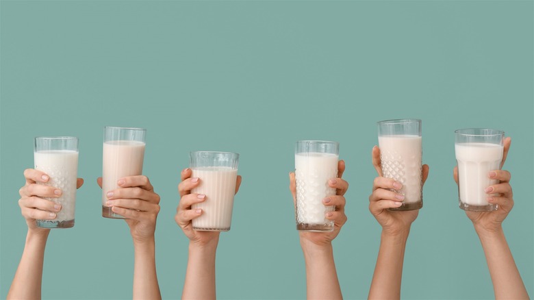 Hands holding vegan milk glasses